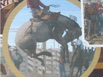 A mural of a guy riding a bucking horse