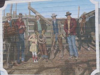 A mural of ranchers in front of a gate