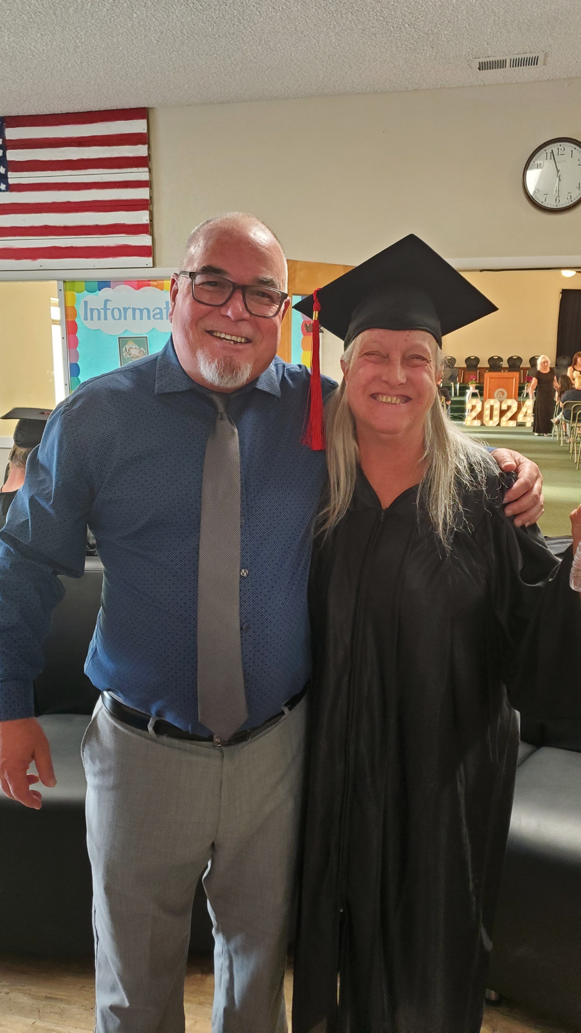 Teacher congratulating adult education graduate