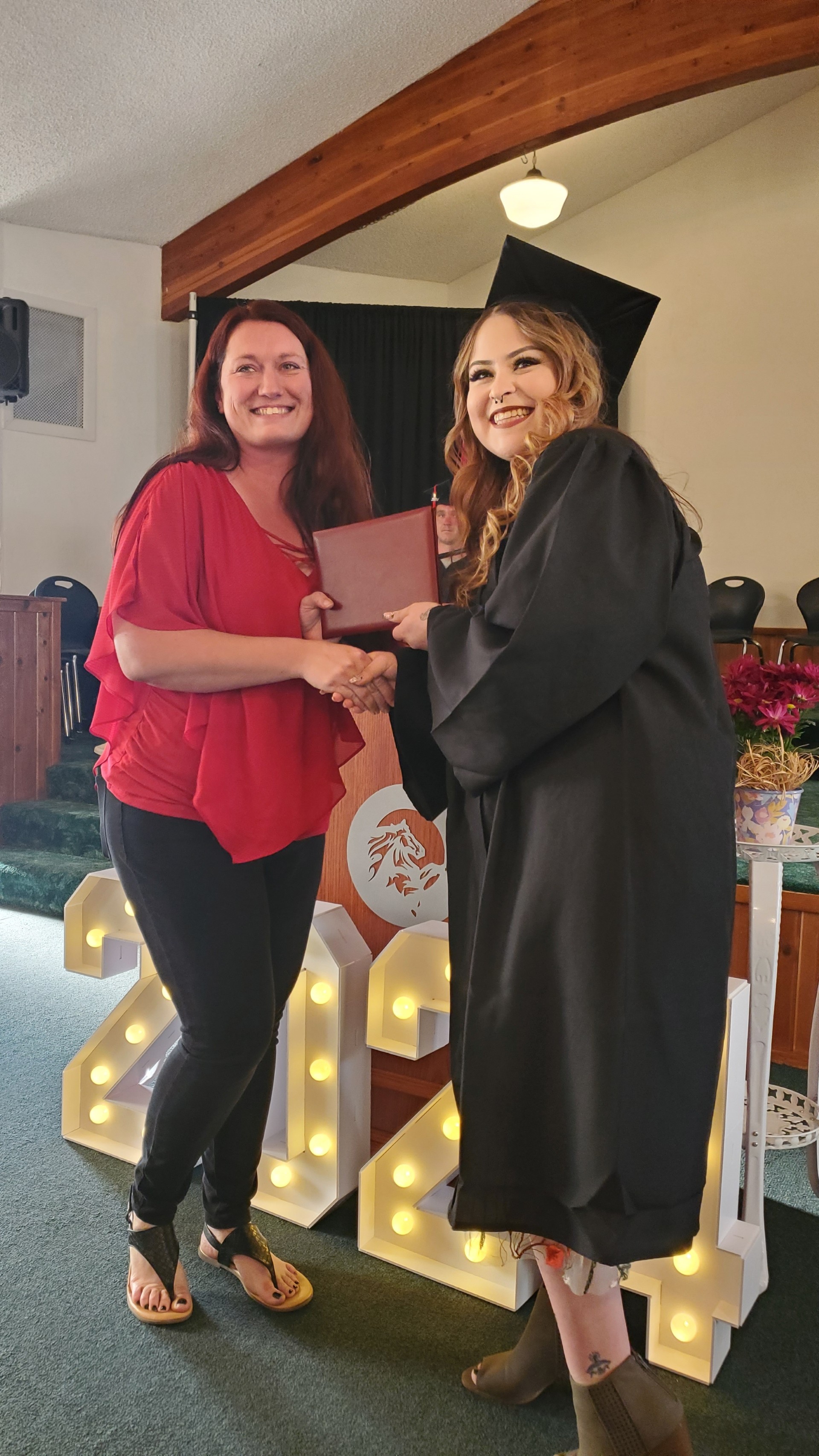 Teacher congratulating adult education graduate 